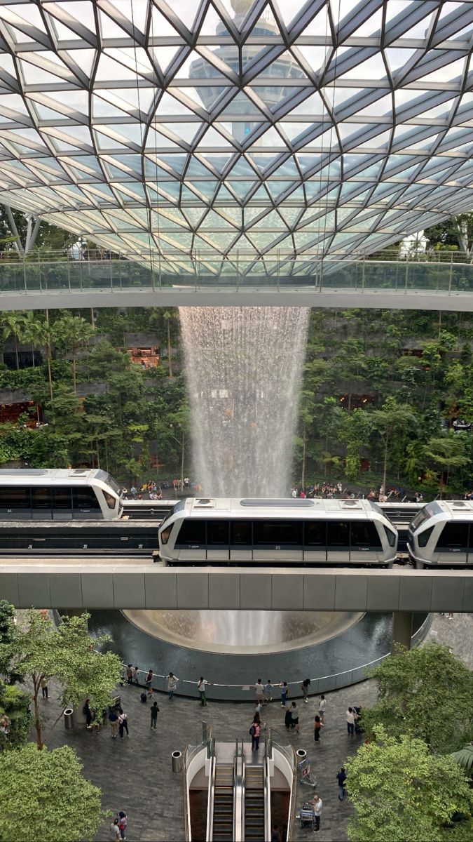 an overhead view of a train station with people walking on the platform and a fountain in the background