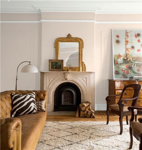 a living room filled with furniture and a fire place next to a painting on the wall