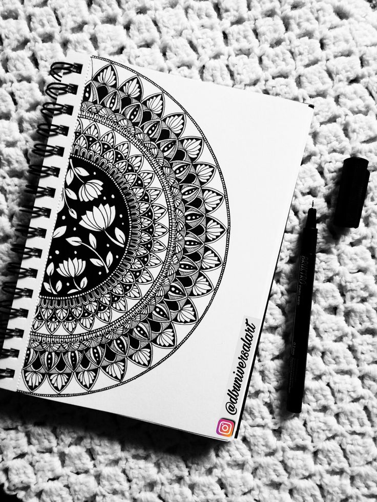 a black and white photo of a spiral notebook on a crocheted tablecloth