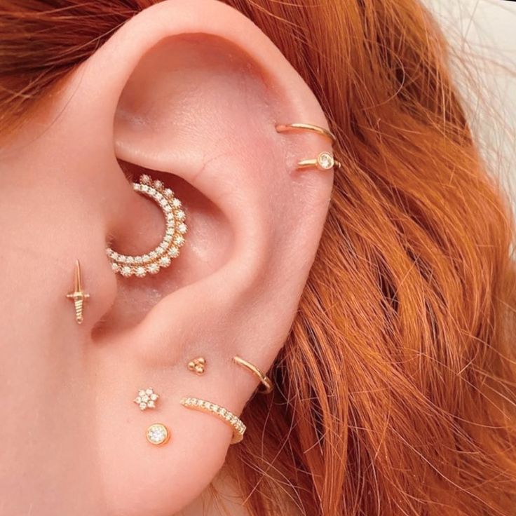 a close up of a person's ear with three different piercings on it