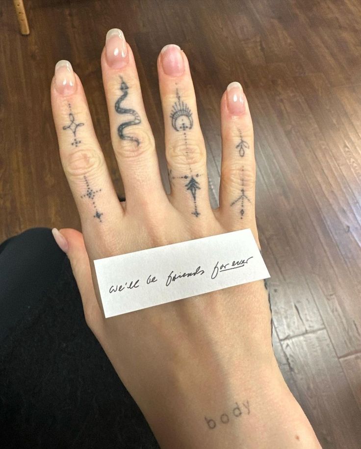 a woman's hand with tattoos on it