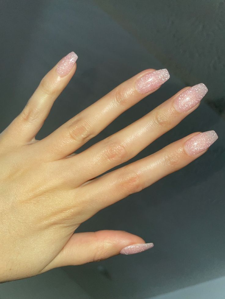 Sparse Glitter Nails, Light Pink Shiny Acrylic Nails, Simple Sparkle Nails Acrylic, Sheer Pink Sparkle Nails, Clear Sparkle Dip Powder Nails, Clear With Sparkle Nails, Light Pink Gel Nails With Glitter, Light Pink Nails 2023, Shimmering Pink Nails