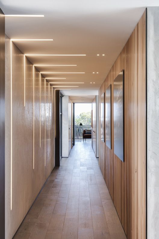 the hallway is lined with wooden paneling and doors