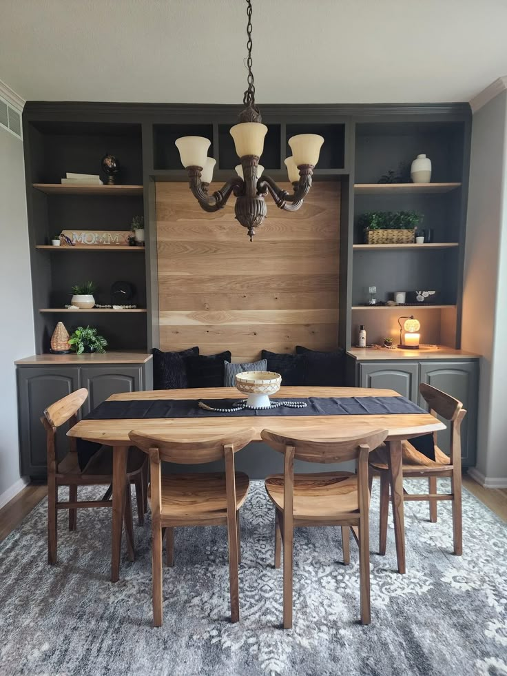 a dining room table and chairs with built in bookshelves behind it on a rug