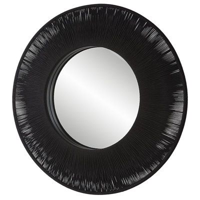 a black round mirror on a white wall