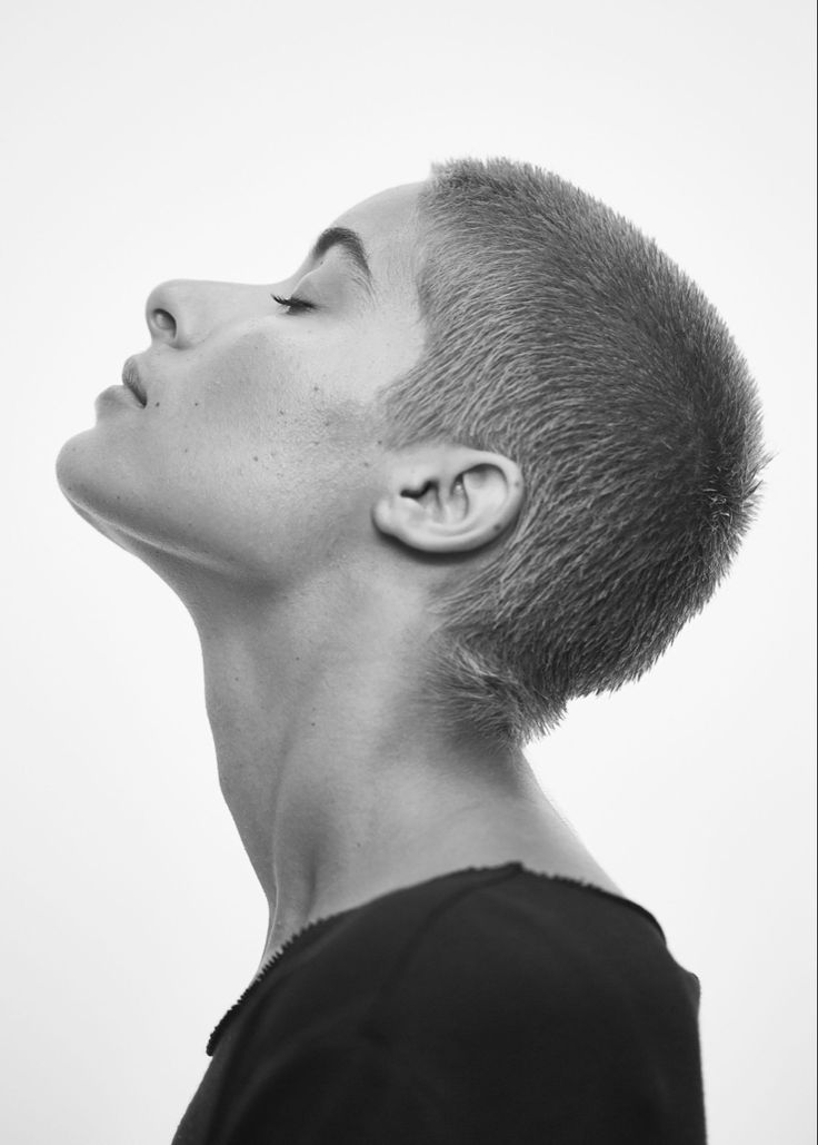 a woman with shaved hair looking up into the sky