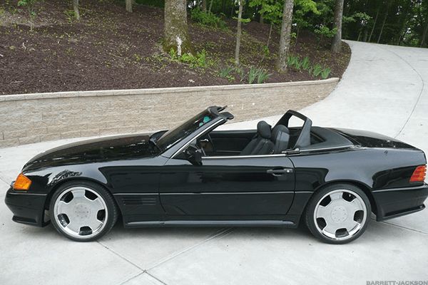 a black convertible car parked on top of a driveway