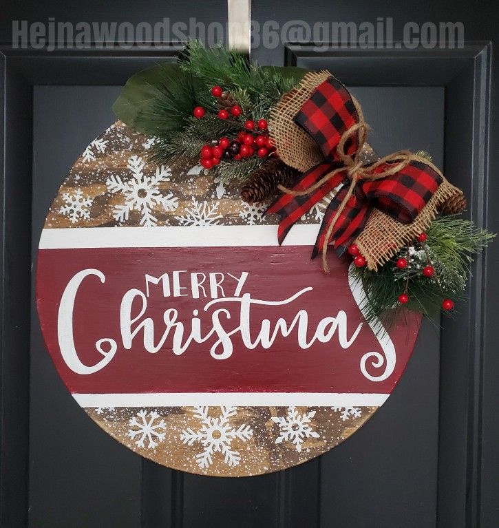 a merry christmas sign hanging on the front door with red and white snowflakes