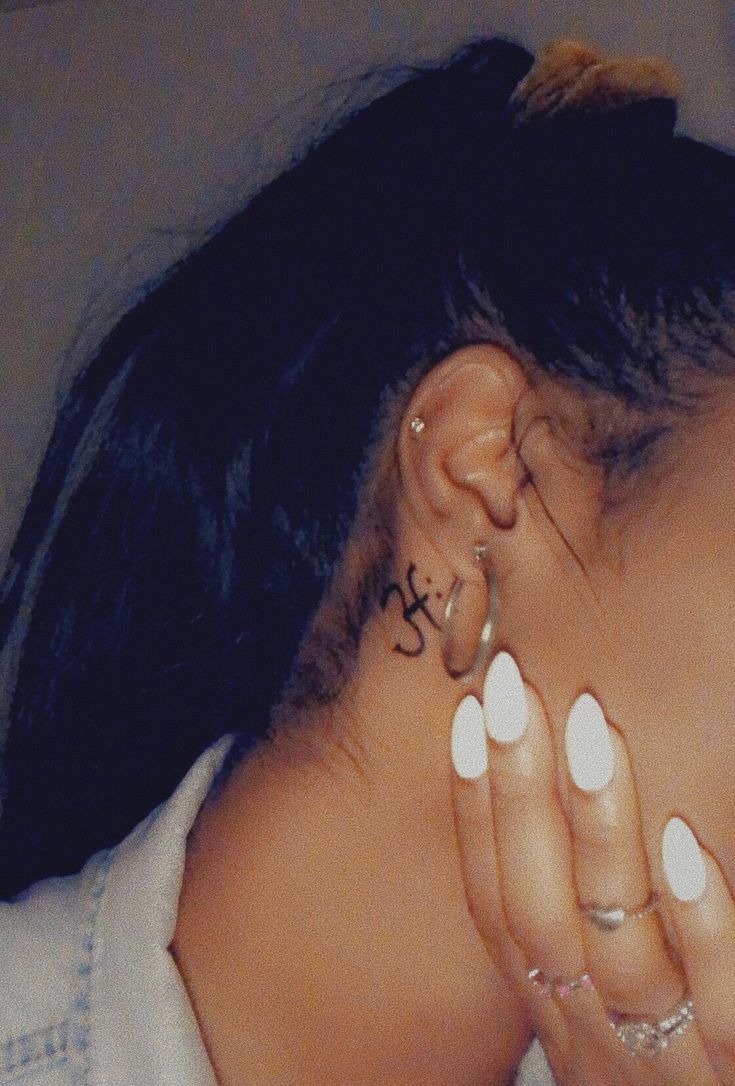 a woman with white nails and piercings on her ear