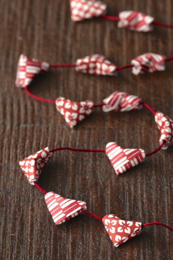 some red and white hearts are on a wooden table, with string attached to them