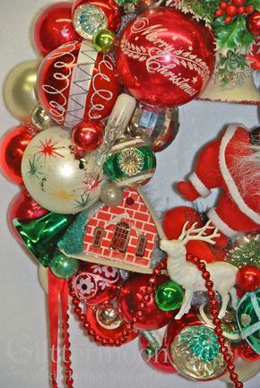 a christmas wreath with ornaments hanging from it's sides and santa clause on the front