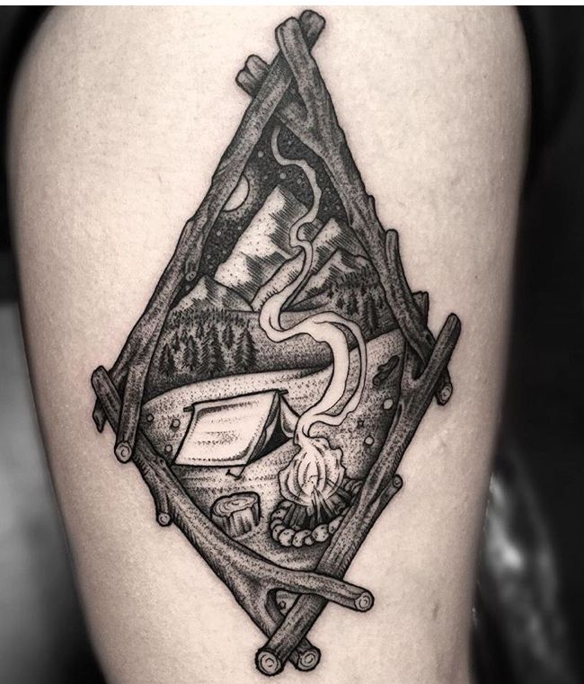 a black and white photo of a tattoo on the thigh