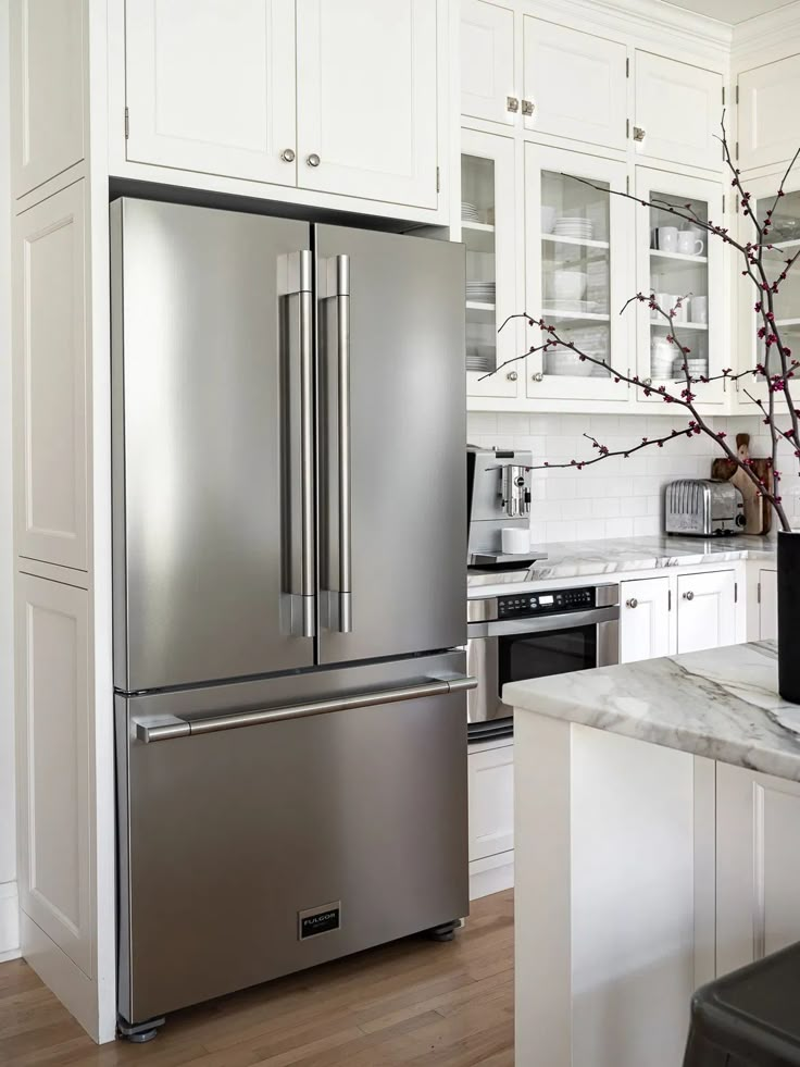 a stainless steel refrigerator in a white kitchen