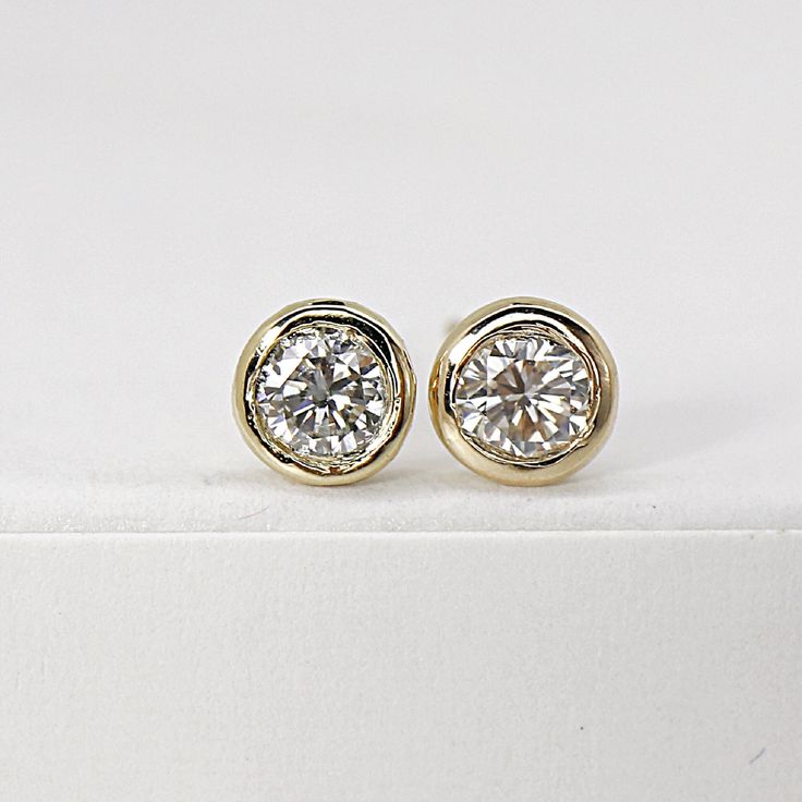 "Add some sparkle to your everyday look with these exquisite 14k gold diamond stud earrings. Each earring boasts a stunning 0.10 ct bezel-set diamond, beautifully crafted in solid gold for a timeless and sophisticated look. These tiny diamond studs are the perfect accessory for any occasion, from bridal earrings to everyday studs that will elevate your outfit effortlessly. DETAILS 14k solid gold studs Round diamonds are 3mm and 0.20 ct. weight total. 0.10 ct. each diamond Earrings size 4.5mm wit Everyday Bezel Set Round Cut Earrings, 14k Gold Round Bezel Set Earrings, 14k Gold Diamond Earrings With Bezel Setting, Yellow Gold Diamond Earrings With Bezel Setting, Wedding Diamond White Earrings With Bezel Setting, Classic 14k Gold Earrings With Bezel Setting, 14k Gold Bezel Set Diamond White Earrings, Minimalist Bezel Set Diamond Earrings For Formal Occasions, Minimalist Diamond Earrings With Bezel Setting For Formal Occasions