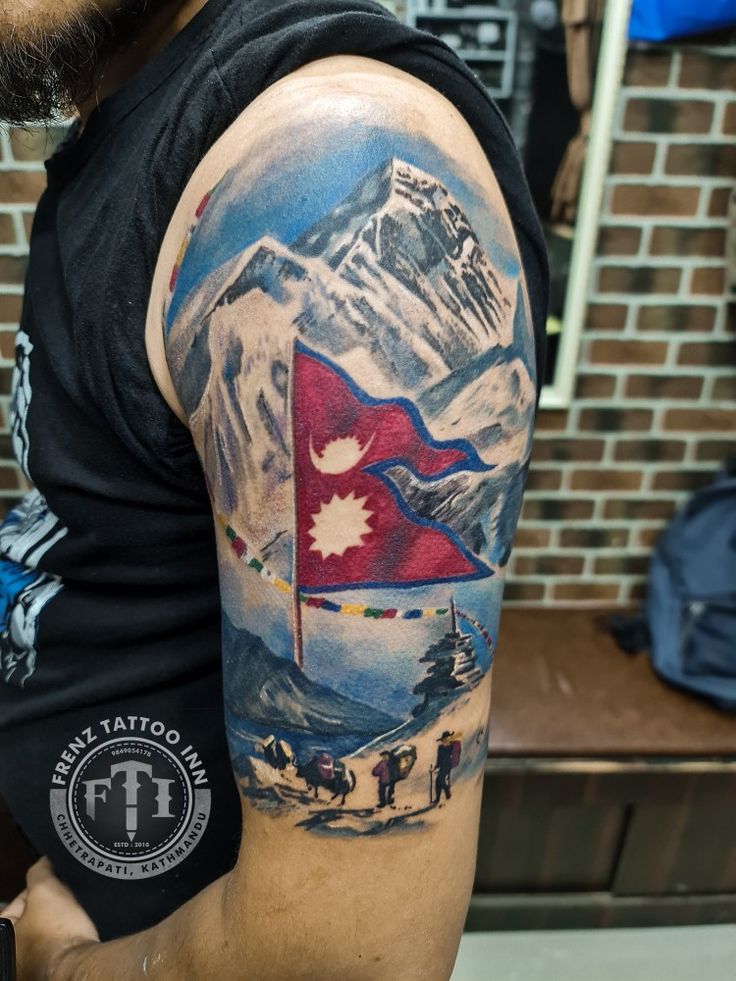 a man with a mountain and flag tattoo on his arm