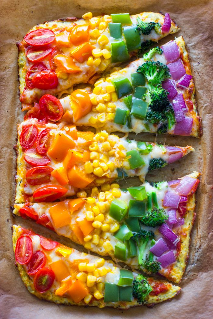 a pizza with many different toppings on it sitting on top of a pan covered in parchment paper