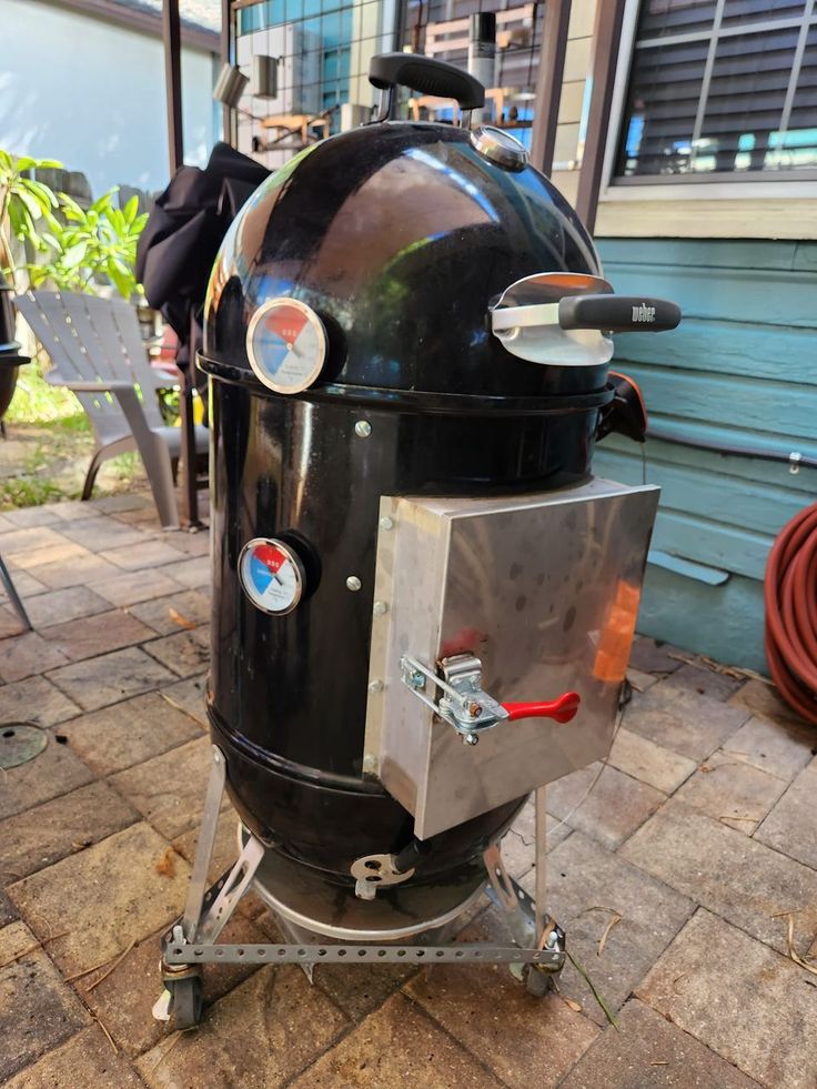 an outdoor bbq grill with wheels on the ground