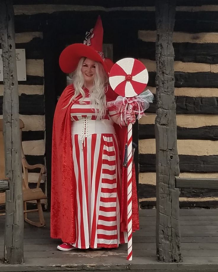 a woman dressed in red and white holding a candy cane