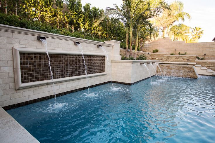 an outdoor swimming pool with water features