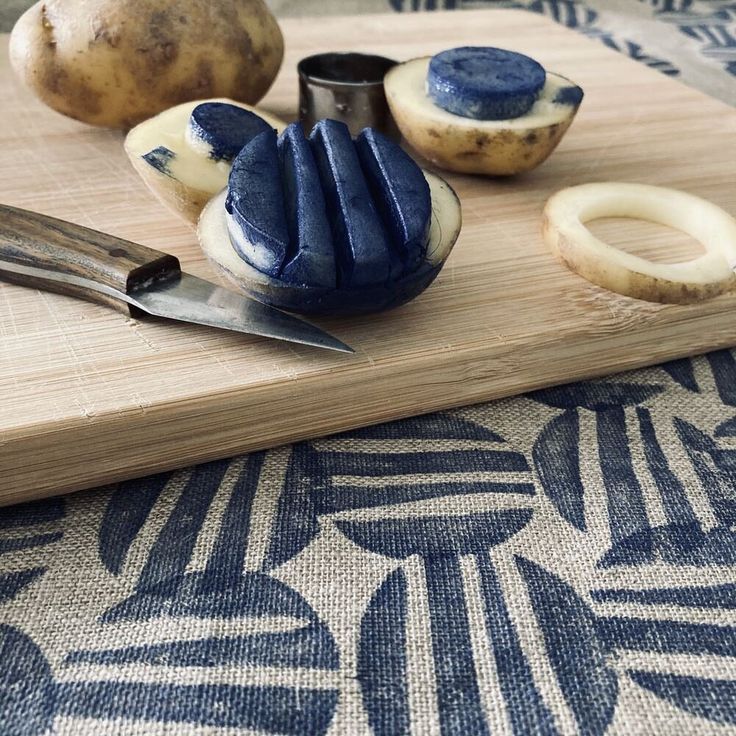 a cutting board topped with different types of food on top of a blue and white table cloth