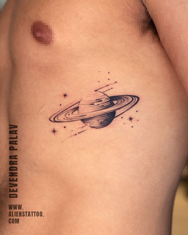 saturn tattoo on the back of a woman's left side ribcage, with stars around it