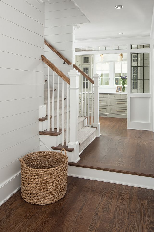 a basket sitting on the floor in front of a stair case next to a set of stairs