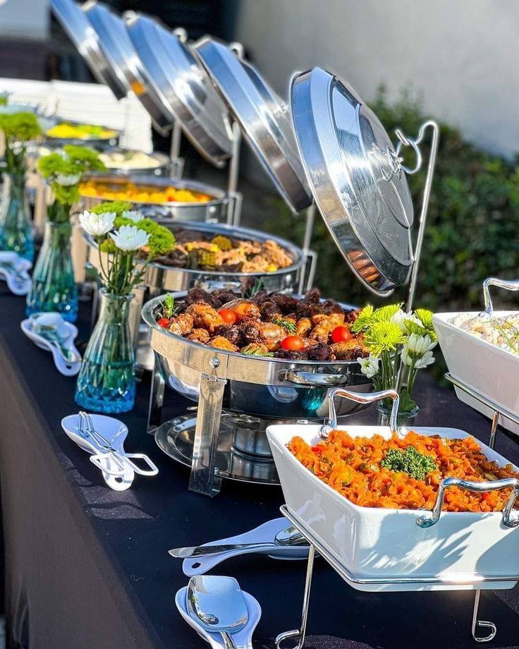 a buffet table with many different types of food and silverware on top of it