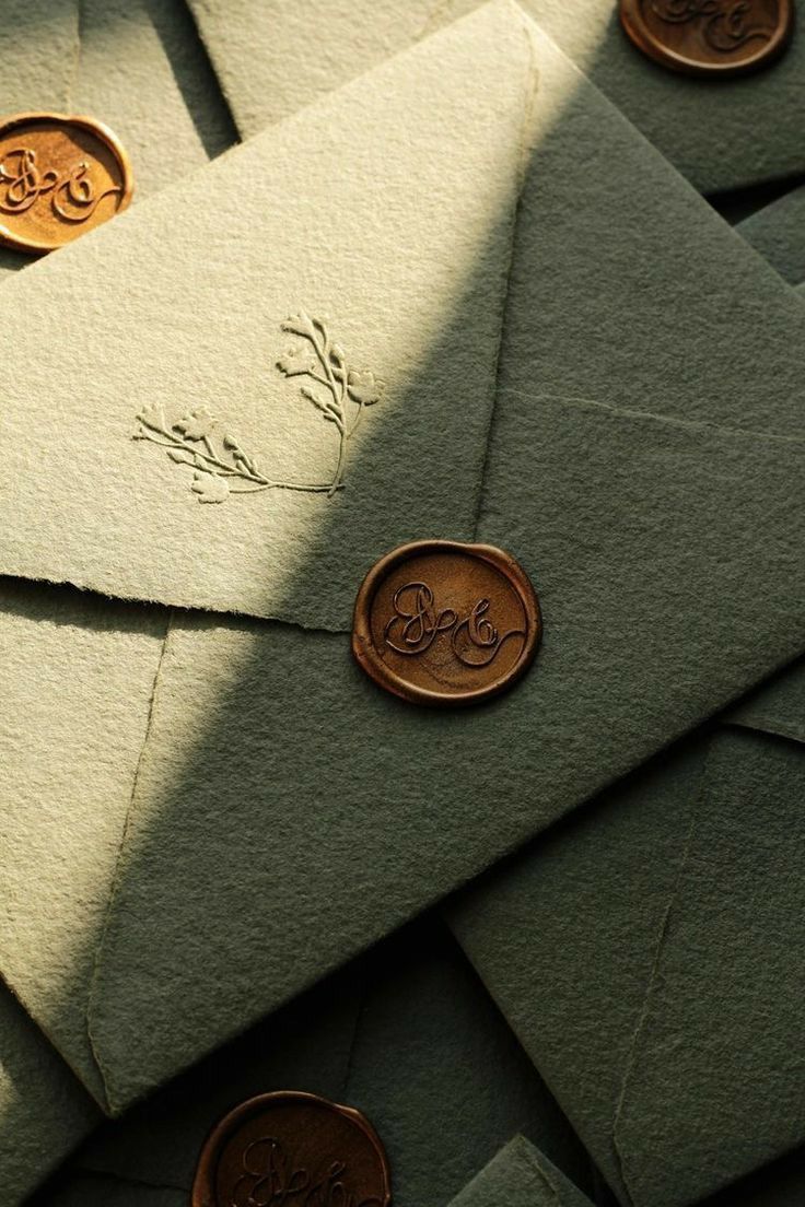 several envelopes with wax stamp on them and some coins laying next to each other