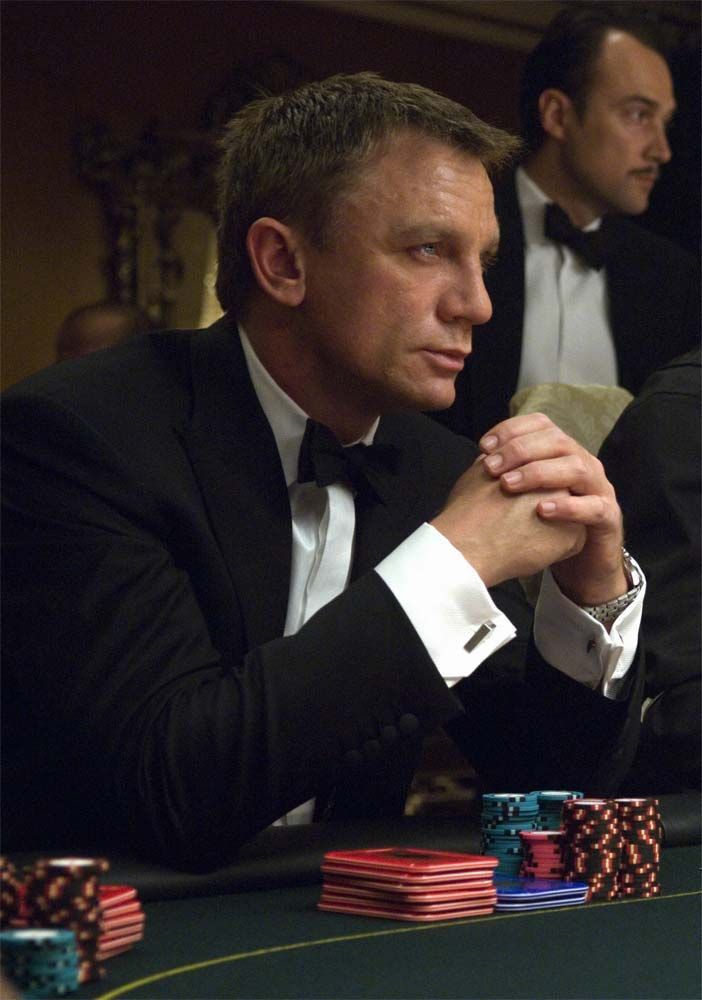 a man in a tuxedo sitting at a table with poker chips