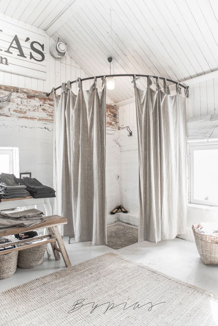 a room that has some curtains on the wall and a table in front of it