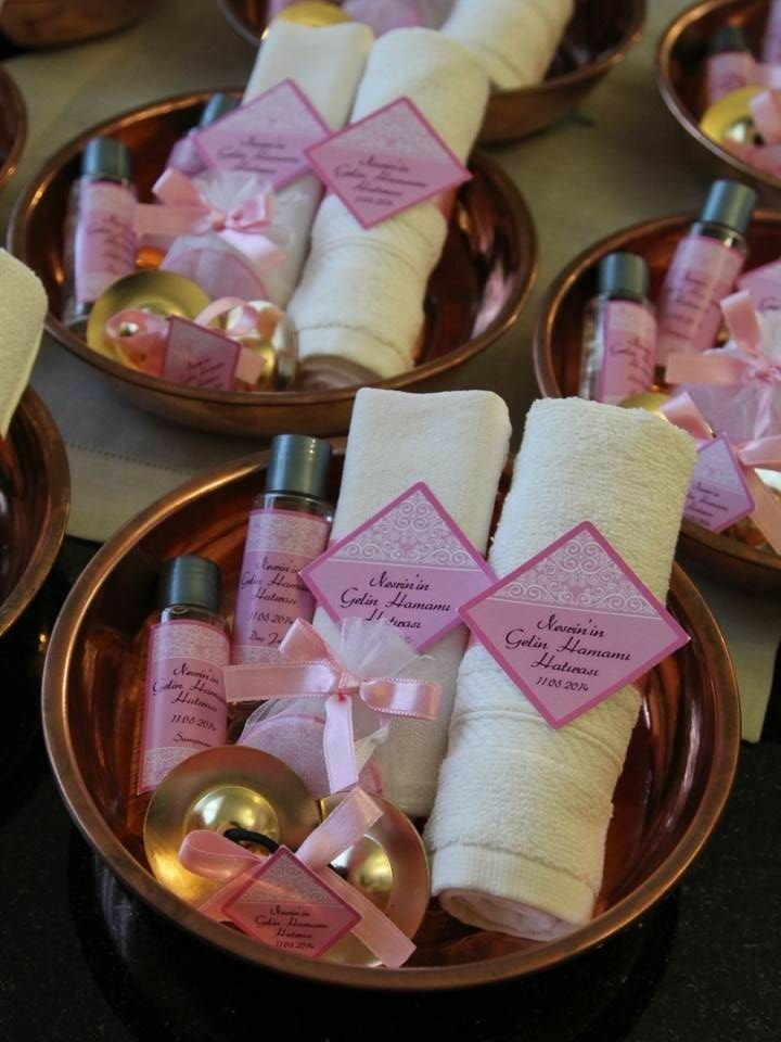 pink and gold dishes with personalized items on them for guests to take home from the ceremony