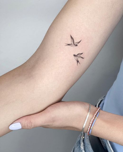 two birds tattoo on the left arm