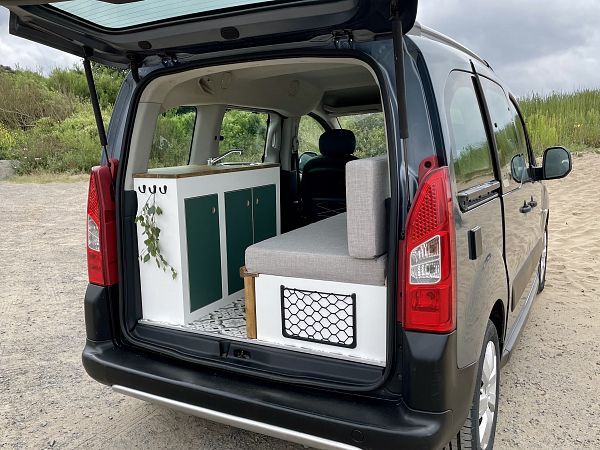 the back end of a van with an open hatchback door and storage area in it