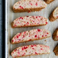 several slices of bread with cranberry toppings on a baking sheet