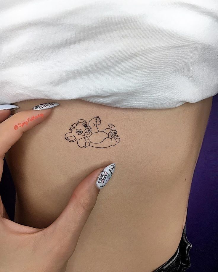 a woman's stomach with a small tattoo on the side of her belly, which has a teddy bear drawn on it