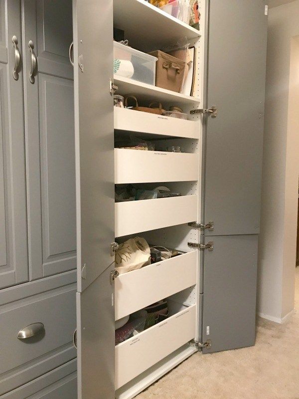 an organized pantry with drawers and pull out shelves