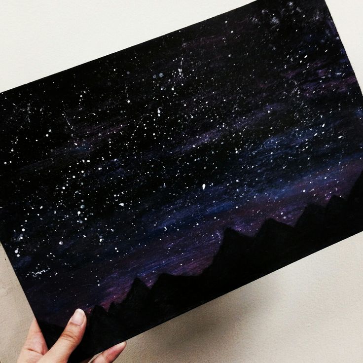 a person holding up a painting with stars in the sky