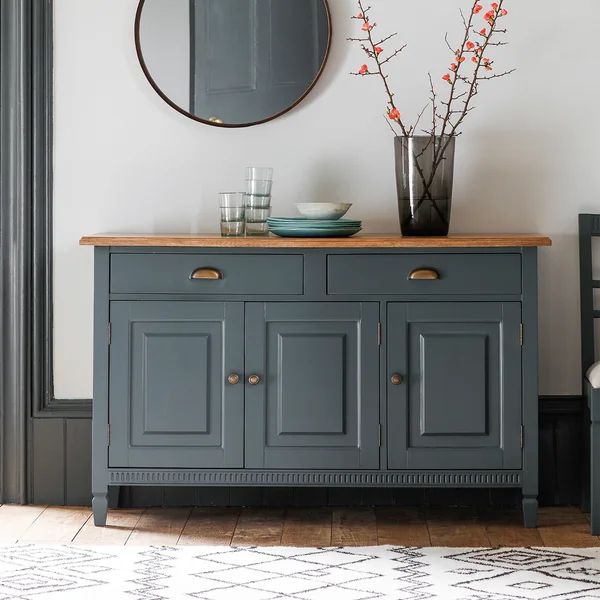 a blue buffet table with two vases on it and a mirror hanging above it