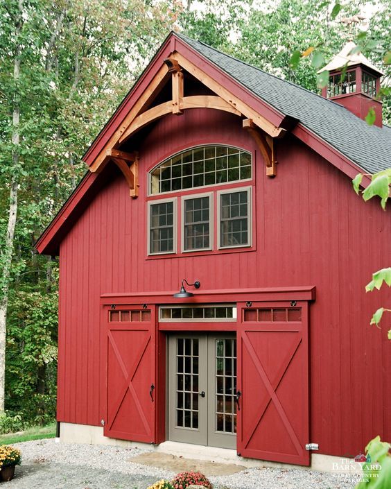 a red barn with two doors and windows