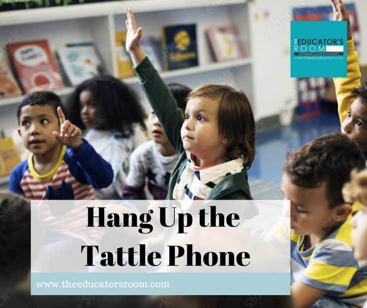 a group of children sitting on the floor with their hands up in front of them