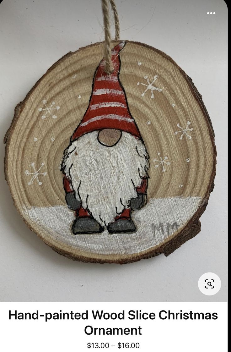 a wooden ornament with an image of a gnome wearing a red and white striped hat