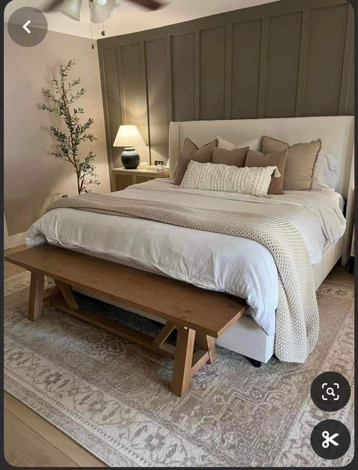 a bedroom with a large bed and a bench on the floor in front of it