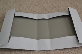 an open box sitting on the floor with paper in it's bottom half and one section missing