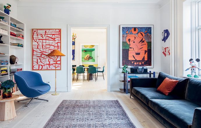 a living room filled with furniture and lots of bookshelves next to a window