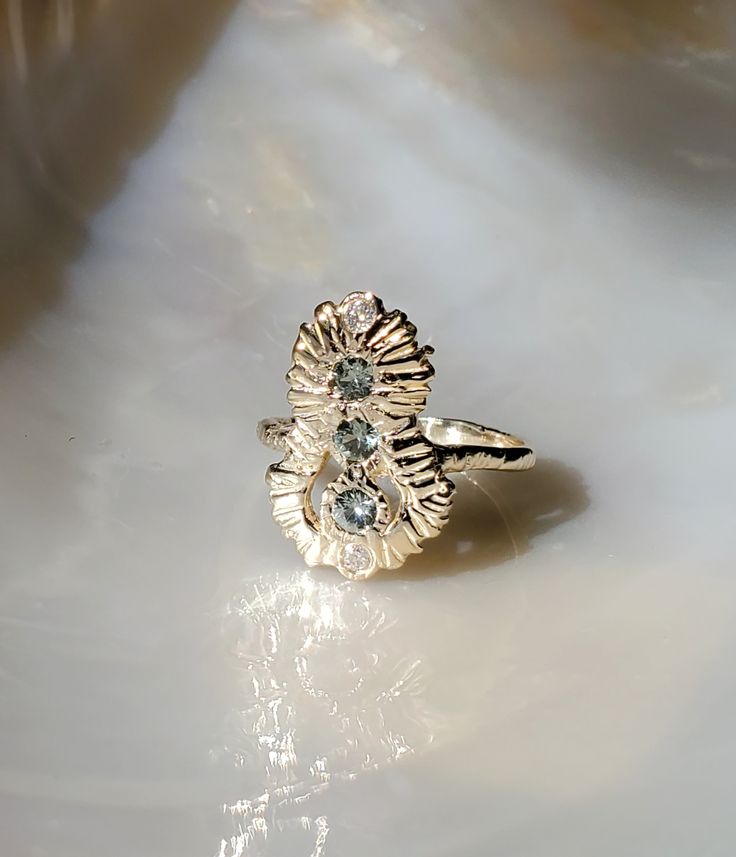 a gold ring with two flowers on it