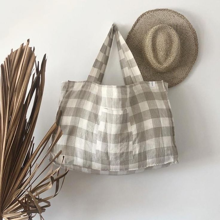 a white and black checkered bag next to a straw hat