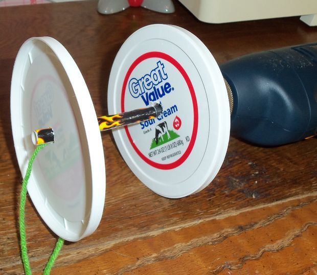 an electric toothbrush is plugged in to a plastic container on a wooden table