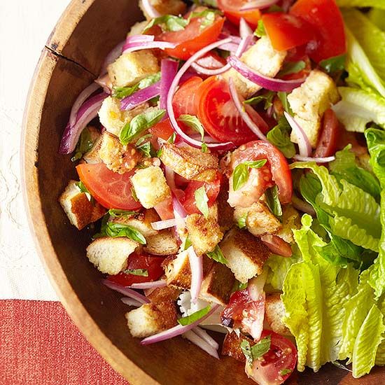 a salad with lettuce and tomatoes in a wooden bowl