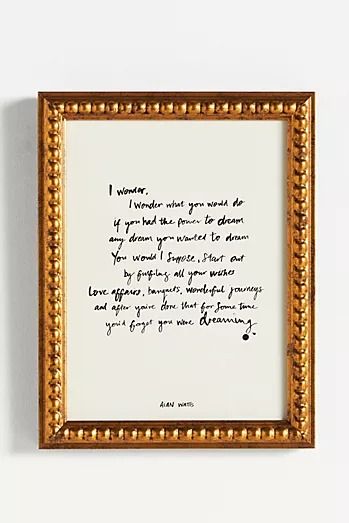 a handwritten poem is framed in an ornate gold frame on the wall above it