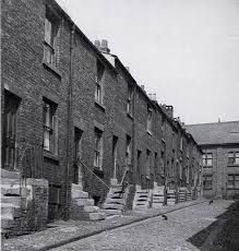 an old black and white photo of brick buildings with stairs leading up to the windows